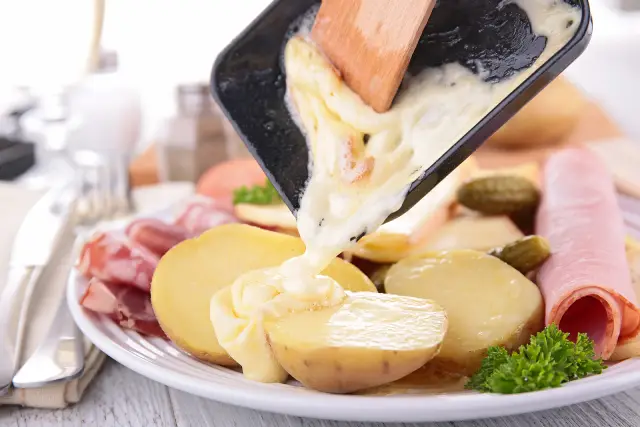 Raclette versée sur une assiette - fromage suisse fondu.