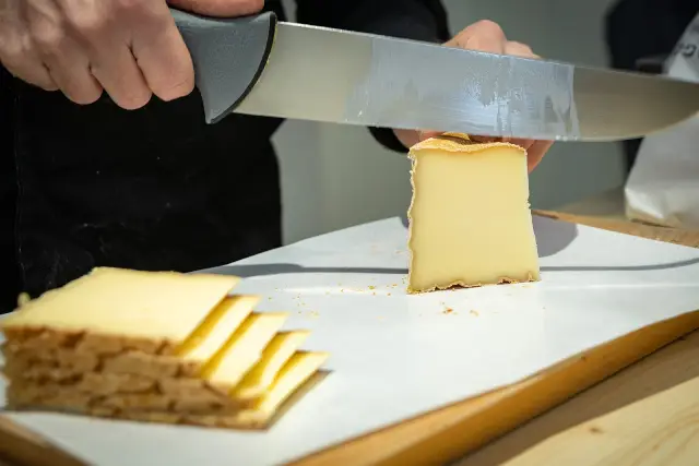 Portion de Vacherin Fribourgeois coupée en tranches.